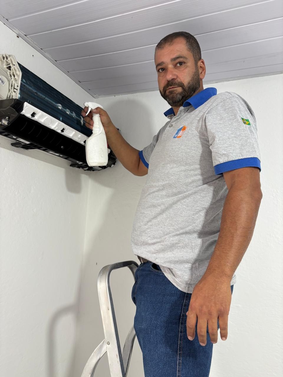 Técnico da JM realizando limpeza e higienização de ar condicionado split